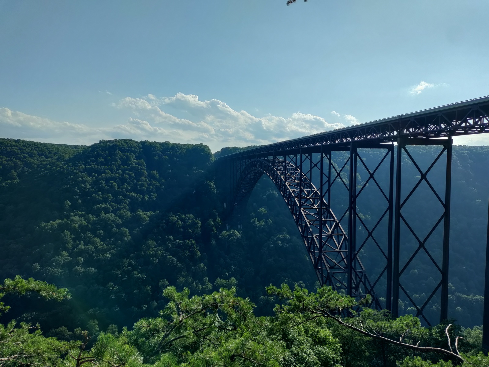 Photo of New River Gorge bridge, with shadows projected through hazy air.